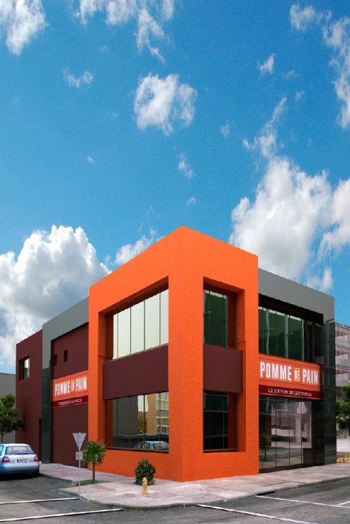 Bâtiment commercial d'angle à façade orange de l'enseigne Pomme de Pain
